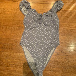 Blue body suited with white flowers and ruffle sleeves